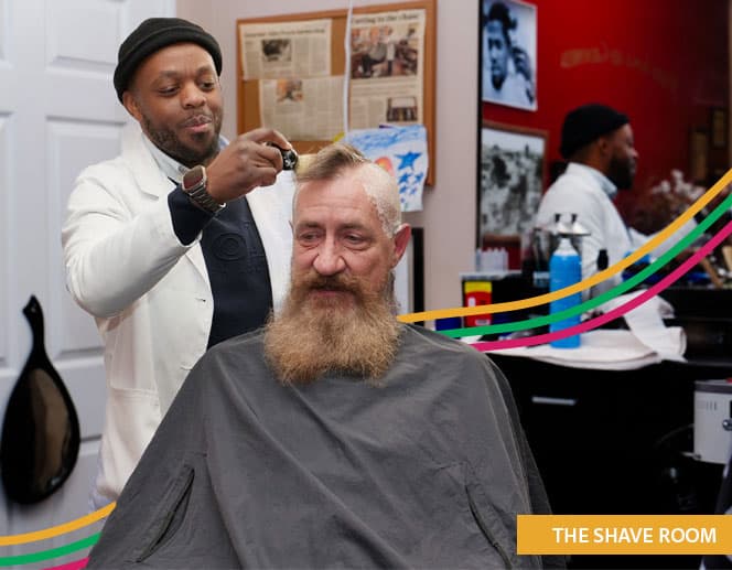 Barber shaving another man's head